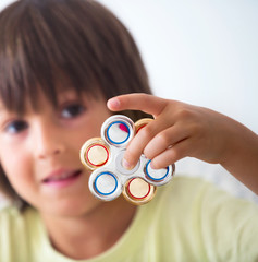 Young boy play with fidget spinner stress relieving toy