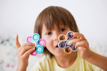 Young boy play with fidget spinner stress relieving toy