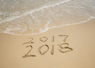 2018 written in sand write on tropical beach