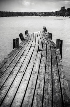 Fototapeta Old wooden foot bridge in sea