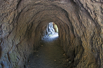 Calabria, Italia: il tunnel scavato nella roccia che porta alla spiaggia dell'Arco Magno, piccola baia nascosta con un arco naturale nato dalla forza delle onde durante i secoli