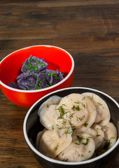 dumplings - pelmeni, ravioli with meat and fish on a wooden background with copy space
