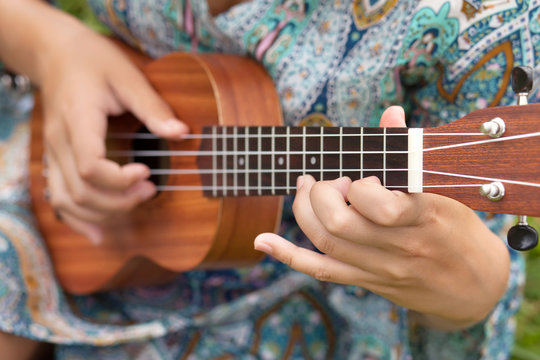 Closeup photo of young woman playing on Ukulel