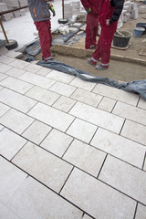 Workers building ancient sidewalk with flagstones