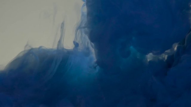 Blue color paint pouring in water. Acrylic colors and ink in water. Abstract frame background. Colors and ink in water