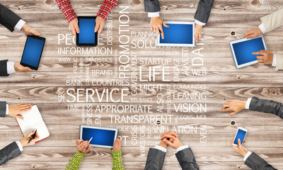 Top view of businesspeople sitting at table and using gadgets
