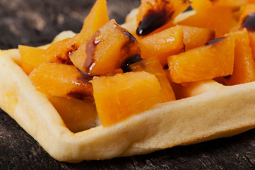 Belgian waffles with pieces of apricot and chocolate sauce.