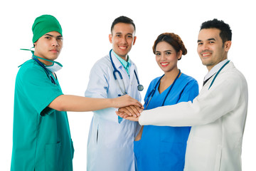 Team of doctor and nurse putting their hands together with stethoscopes over isolated white background. Team with stack of hands showing unity and teamwork.