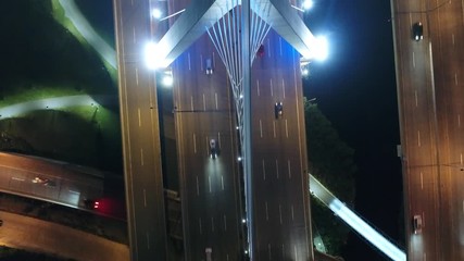 Flying over a steel cable suspension bridge at night lights