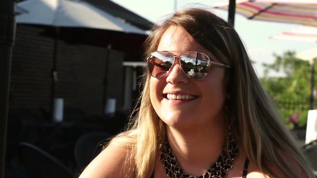 Fashionable millennial woman in outdoor dining area looking at phone