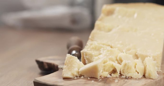 slide pieces of hard parmesan cheese on olive board