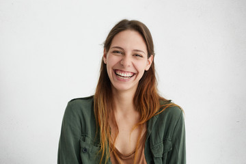 Good-looking female with sincere smile rejoicing her success at work having good mood showing her...