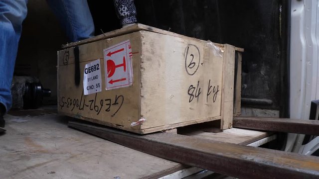 Box by fork-lift stacker loader. Fork-lift in loading dig box into a car