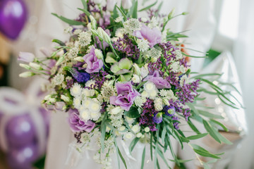 Beautiful purple wedding bouquet in bride's hands