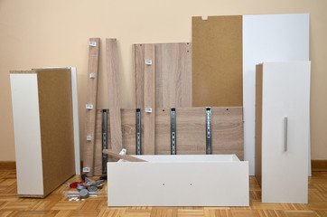 Pile of unpacked elements of a new chest of drawers ready for assembling