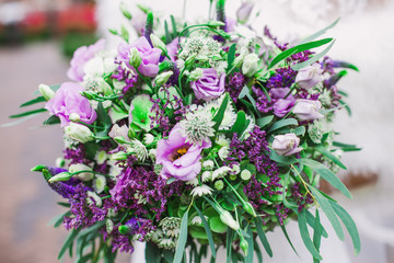 Obraz na płótnie Canvas Beautiful purple wedding bouquet in bride's hands