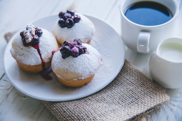 cupcakes with berries on white wooden background