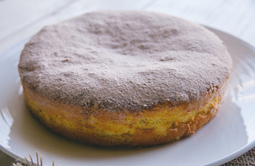 Homemade apple cake biscuit close up of a slice of cake on white plate on white wooden background 