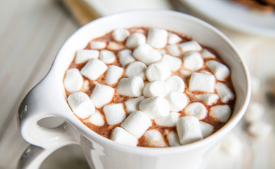 Breakfast for couple included oat pancakes with banana, nutella, honey, with coffe and milk and cacao with marshmallow on white wooden  background