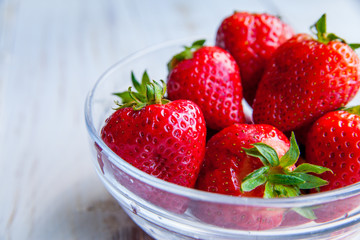 Strawberries on the plate on white wooden background for breakfast 