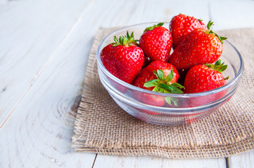 Strawberries on the plate on white wooden background for breakfast 