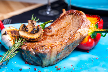 Veal steak with grilled vegetables: mushrooms and peppers on the grill, rosemary and chili