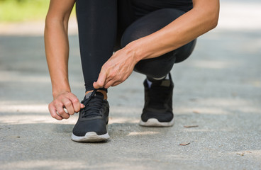 Obraz premium runner woman tie shoe in a park