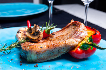 Veal steak with grilled vegetables: mushrooms and peppers on the grill, rosemary and chili