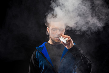 vaping man holding a mod. A cloud of vapor.