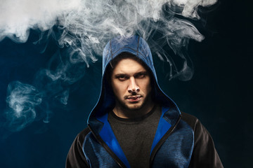 vaping man holding a mod. A cloud of vapor.