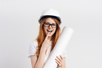 Beautiful young woman engineer on white isolated background holds blueprints