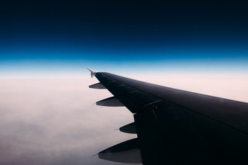 Obraz premium View from airplane window on clouds beneath and clear dark blue