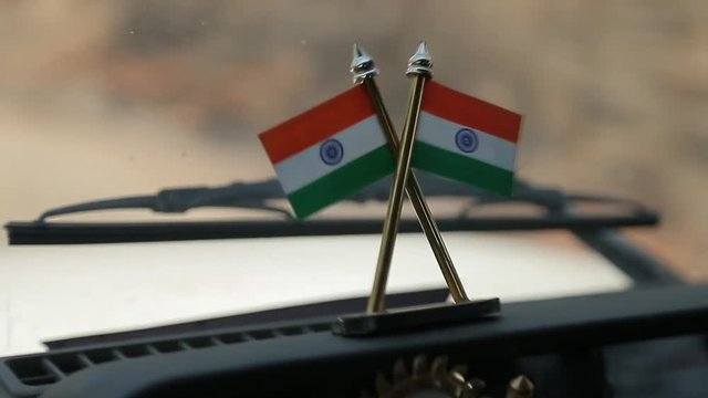 The movement of the car on the road. Small Indian flags