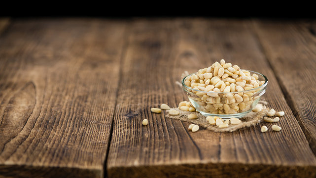 Wooden table with Pine Nuts (selective focus)