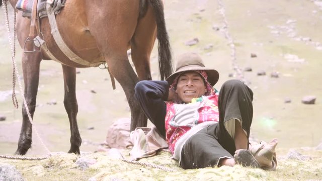 Peruvian muleteer resting near horse wearing the typical costume of the highlands. Slow motion