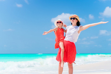 Little adorable girl and young mother at tropical beach. Family of two have a lot of fun during...