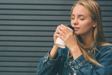 pretty girl sitting in street with morning coffee and relaxing