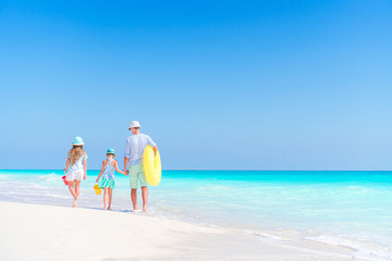 Obraz na płótnie Canvas Family of dad and kids walking on white tropical beach on caribbean island