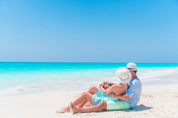 Young couple on white beach during summer vacation. Happy lovers enjoy their honeymoon