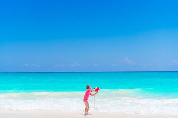 Fototapeta na wymiar Little girl play with beach toys during tropical vacation