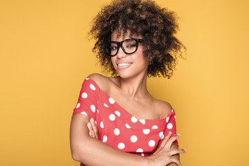 African american girl in eyeglasses on yellow background.
