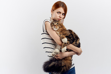 Beautiful young woman on white isolated background holds a cat, an allergy