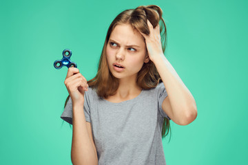 Beautiful young woman on a green background holds a spinner