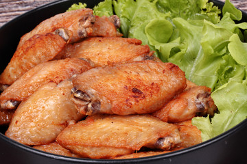 Deep fried chicken wings topped green oak.