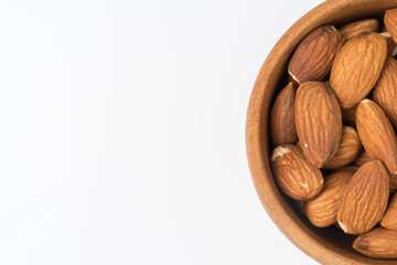 Almond in wooden bowl isolated on white background. Top view