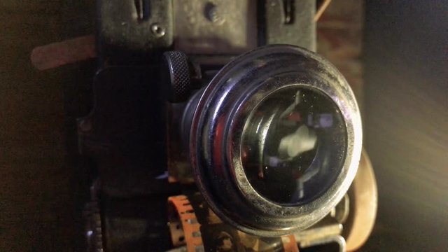 Spooky 1920s film projector closeup with light on