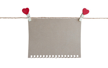 wooden clothespin with heart shape design and brown paper sheet for valentine concept isolated on white background