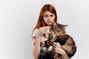 Beautiful young woman on white isolated background holds a cat