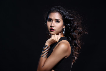 low key portrait of tan skin asian slim healthy woman in black background