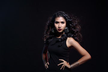 low key portrait of tan skin asian slim healthy woman in black background